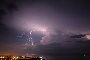 Tropisches Gewitter Gewitterblitze am Nachthimmel über einer Stadt