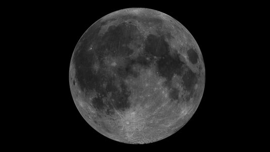 Mond mit dunklen und hellen Flecken vor dunklem Hintergrund.