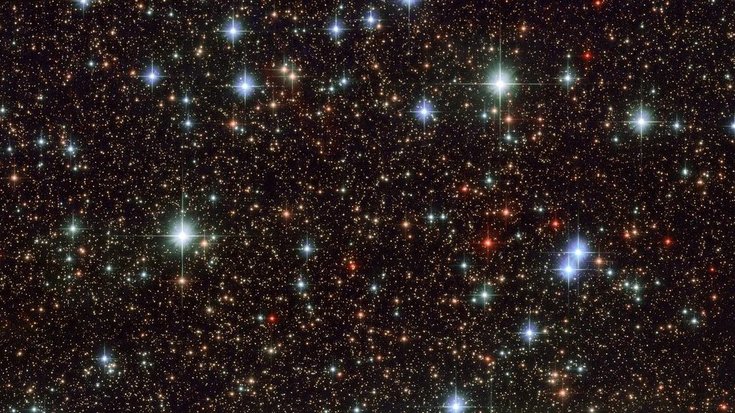 Die Aufnahme von Hubble zeigt sehr viele Sterne im Weltall, die unregelmäßig verteilt sind. 