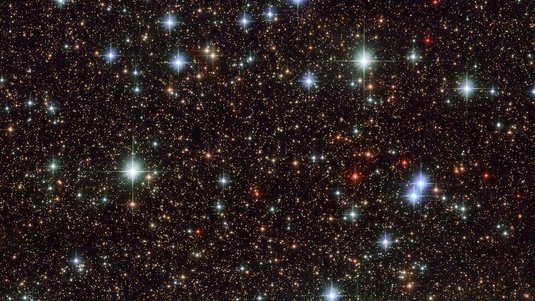 Die Aufnahme von Hubble zeigt sehr viele Sterne im Weltall, die unregelmäßig verteilt sind. 