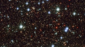 Die Aufnahme von Hubble zeigt sehr viele Sterne im Weltall, die unregelmäßig verteilt sind. 