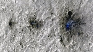 Satellitenbild von drei Einschlagskratern; nach rechts sind die Krater größer, dunkler und farbintensiver dargestellt.