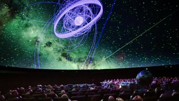 Sternenhimmel im sonst dunklen, menschengefüllten Planetarium