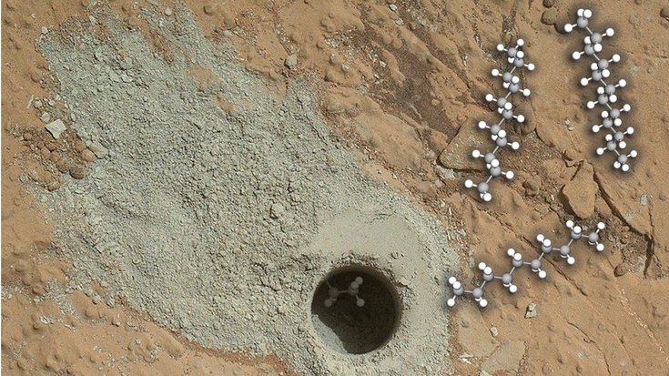 Kreisrunde Bohrloch in einem Felsen auf dem Mars. Um das Loch verteilt ist feiner Sand vom Bohren. Darin und darüber sind lange Molekütten skizziert. 